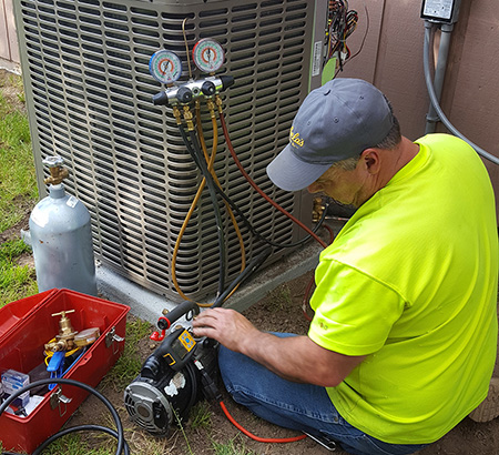 Technician working on outdoor residential unit